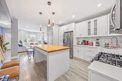 a kitchen with white cabinets and a wooden counter top at Newark's Family Favorite Place in Newark