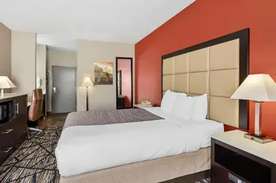 a hotel room with a large bed and red walls at Best Western Carlisle in Carlisle
