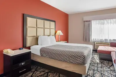 a hotel room with a large bed with orange walls at Best Western Carlisle in Carlisle
