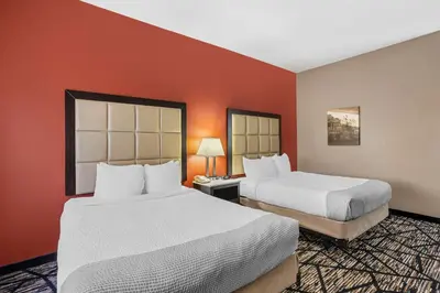 two beds in a hotel room with red walls at Best Western Carlisle in Carlisle