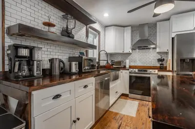 a kitchen with white cabinets and a wooden counter top at Pocono Retreat Movies Games Spacious in Long Pond