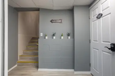 a hallway with stairs and a door with potted plants at Pocono Retreat Movies Games Spacious in Long Pond