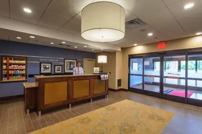 a man standing at a counter in a waiting room at Hampton Inn & Suites Philadelphia/Bensalem in Bensalem