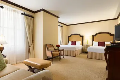 a hotel room with two beds and a couch at Hotel Du Pont in Wilmington