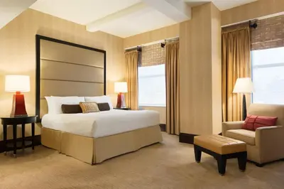 a bedroom with a large bed and a chair at Hotel Du Pont in Wilmington