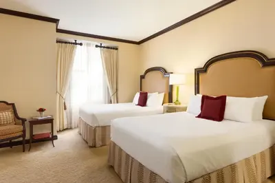 a hotel room with two beds and a chair at Hotel Du Pont in Wilmington