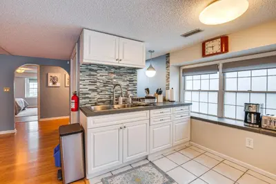 a kitchen with white cabinets and a brick wall at 7 Mi to Newark Montclair Vacation Rental in Montclair