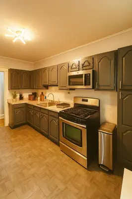 a kitchen with black cabinets and a stove at Spacious 4BR near NYC with Parking, 10min MetLife, 20min Times Sq in North Bergen