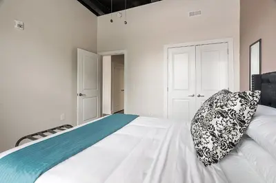 a bedroom with a white bed with a pillow on it at A Luxury Urban 1BR Queen Bed-Parking - Heart of Historic Germantown - Temple & LaSalle -106- Stay Long Term! in Philadelphia