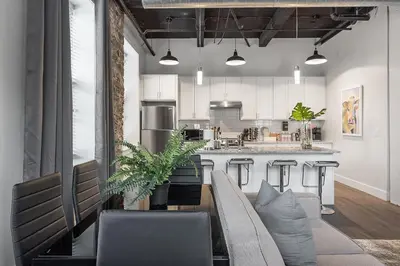 a living room with a couch and a kitchen at A Luxury Urban 1BR Queen Bed-Parking - Heart of Historic Germantown - Temple & LaSalle -106- Stay Long Term! in Philadelphia