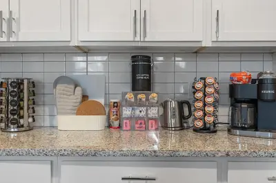 a kitchen counter top with a coffee maker and food at A Luxury Urban 1BR Queen Bed-Parking - Heart of Historic Germantown - Temple & LaSalle -106- Stay Long Term! in Philadelphia
