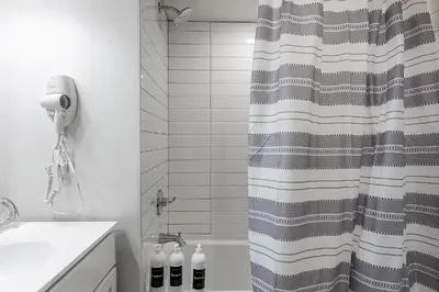 a bathroom with a shower curtain and a sink at A Luxury Urban 1BR Queen Bed-Parking - Heart of Historic Germantown - Temple & LaSalle -106- Stay Long Term! in Philadelphia