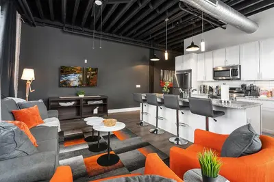a living room with orange furniture and a kitchen at Luxury Urban 1BR King Bed-Parking - Heart of Historic Germantown - Temple & LaSalle -105- Stay Long Term! in Philadelphia