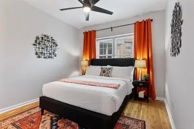 a bedroom with a large bed with an orange curtain at Fitler Square GEM - 3 Bedrooms in Philadelphia