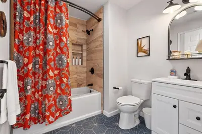 a bathroom with a red shower curtain and a toilet at Fitler Square GEM - 3 Bedrooms in Philadelphia