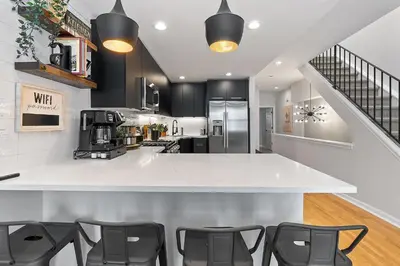 a kitchen with a white counter and some chairs at Fitler Square GEM - 3 Bedrooms in Philadelphia