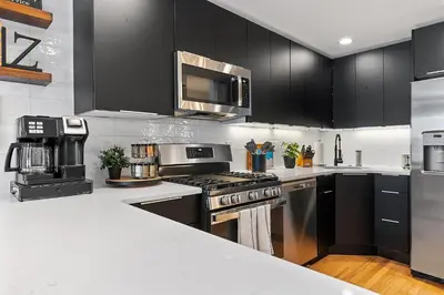 a kitchen with stainless steel appliances and black cabinets at Fitler Square GEM - 3 Bedrooms in Philadelphia