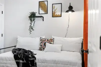 a room with a white bed with pillows and a lamp at Fitler Square GEM - 3 Bedrooms in Philadelphia
