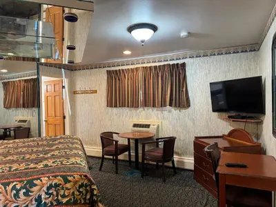 a hotel room with a bed and a table and a tv at Royal Motel in Secaucus