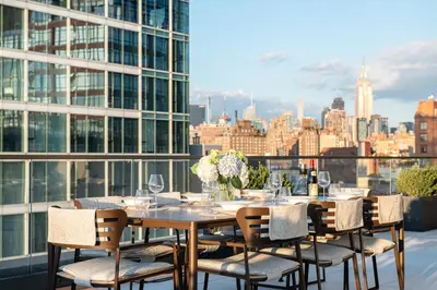 a table with chairs and wine glasses on top of a building at Maison Hudson in New York
