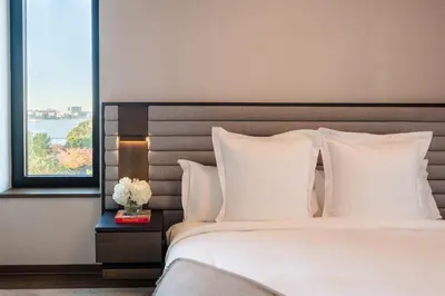 a bedroom with a bed with white pillows and a window at Maison Hudson in New York