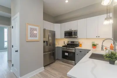 a kitchen with stainless steel appliances and white cabinets at PRISTINE 3 bdrm - Garage Parking - Close to UPENN in Philadelphia