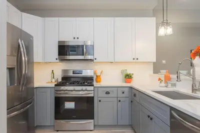 a kitchen with white cabinets and stainless steel appliances at PRISTINE 3 bdrm - Garage Parking - Close to UPENN in Philadelphia