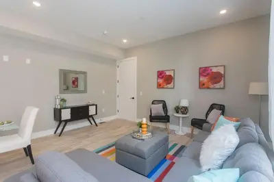 a living room with a blue couch and a table at PRISTINE 3 bdrm - Garage Parking - Close to UPENN in Philadelphia