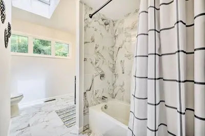 a bathroom with a tub and a toilet and a shower curtain at Oasis Hot Tub Pool Game Room in Saylorsburg