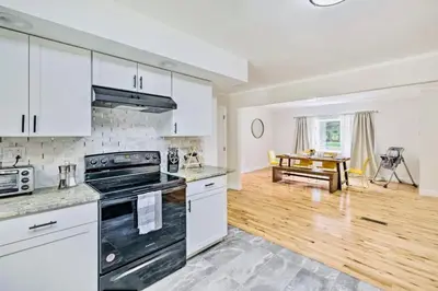 a kitchen with white cabinets and a stove top oven at Oasis Hot Tub Pool Game Room in Saylorsburg