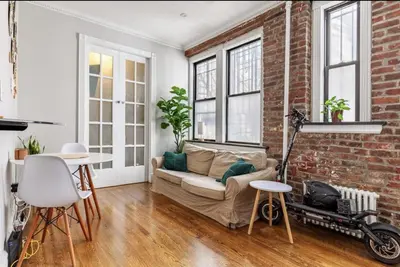 a living room with a couch and a brick wall at Private Room at a 3 bedroom Apt at the heart of East Village - shared apartment in New York