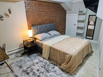 a bed in a room with a brick wall at Private Room at a shared Apartment at the Heart of East Village in New York