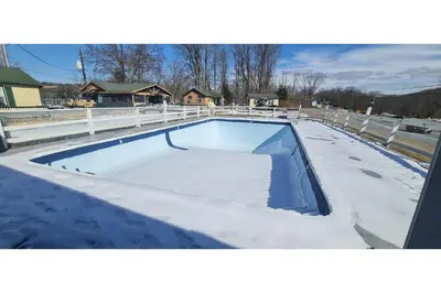 a swimming pool with snow on the top of it at Werry's Cottages Motel & Pub by OYO East Stroudsburg Poconos in East Stroudsburg