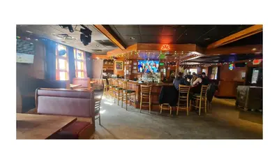 a bar in a restaurant with people sitting at tables at Werry's Cottages Motel & Pub by OYO East Stroudsburg Poconos in East Stroudsburg