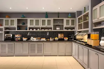 a large kitchen with white cabinets and appliances at Hyatt Place Mt. Laurel in Mount Laurel