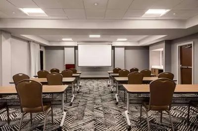 a conference room with tables and chairs and a projection screen at Hyatt Place Mt. Laurel in Mount Laurel