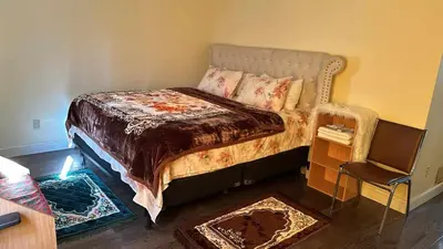 a bedroom with a bed and a chair at Divine Villa and Resorts 67 Sherman 5mins to EWR Airport and 4mins to Penn Station Newark, 20Mins to New York in Newark