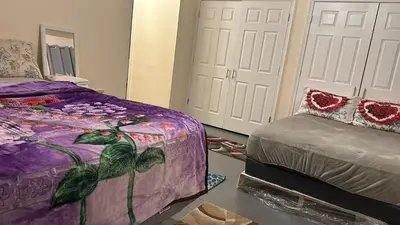 a bedroom with a purple bed and two white doors at Divine Villa and Resorts 67 Sherman 5mins to EWR Airport and 4mins to Penn Station Newark, 20Mins to New York in Newark