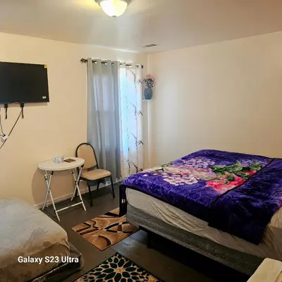 a bedroom with a bed and a small table at Divine Villa and Resorts 67 Sherman 5mins to EWR Airport and 4mins to Penn Station Newark, 20Mins to New York in Newark