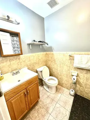 a bathroom with a toilet and a sink at Room G DIVINE VILLA AND RESORT, 6 MINS TO AIRPORT, 4MINS TO PENN STATION. in Newark