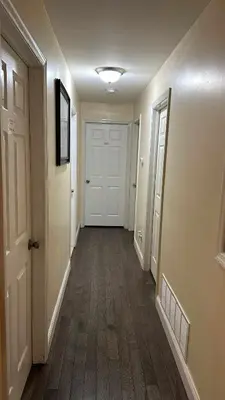a hallway with a white door and wooden floors at Room J Divine Villa and Resorts 5mins to EWR Airport and 4mins to Penn Station Newark, New York in Newark