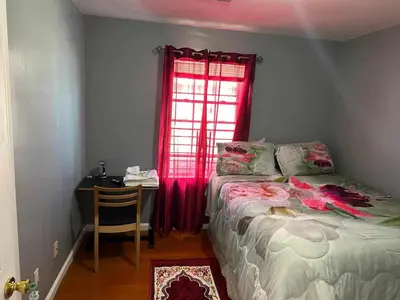 a bedroom with a bed and a desk and a window at Room J Divine Villa and Resorts 5mins to EWR Airport and 4mins to Penn Station Newark, New York in Newark
