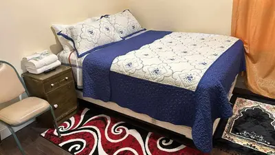 a bedroom with a bed and a chair and a table at Room J Divine Villa and Resorts 5mins to EWR Airport and 4mins to Penn Station Newark, New York in Newark
