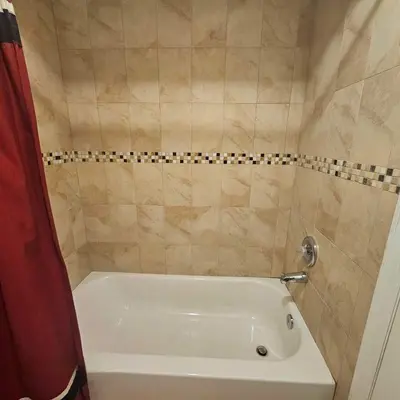a bathroom with a white bath tub with a red shower curtain at Room K Divine Villa and Resorts 5mins to EWR Airport and 4mins to Penn Station Newark, New York in Newark