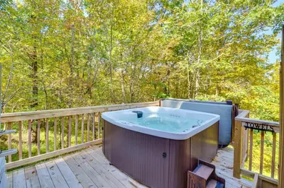 a hot tub on a deck with trees at Pocono Getaway A frame Cabin w/ Hot Tub Sauna in East Stroudsburg