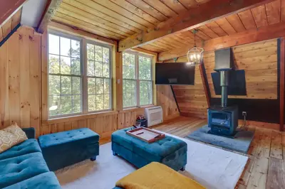 a living room with a couch and a stove at Pocono Getaway A frame Cabin w/ Hot Tub Sauna in East Stroudsburg