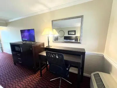 a hotel room with a desk and a mirror at Kiteville Lancaster in Strasburg