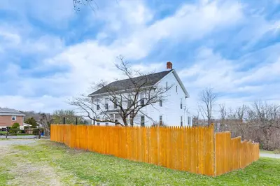 an orange fence in front of a white house at Pet and Family Friendly! Home with Fenced Yard and Deck in York Haven