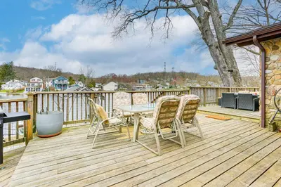 a patio with a table and chairs on a deck at Waterfront Lake Hopatcong Home with Boat Dock! in Mount Arlington
