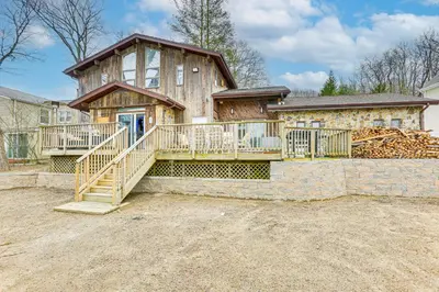 a large house with a large deck on the front of it at Waterfront Lake Hopatcong Home with Boat Dock! in Mount Arlington